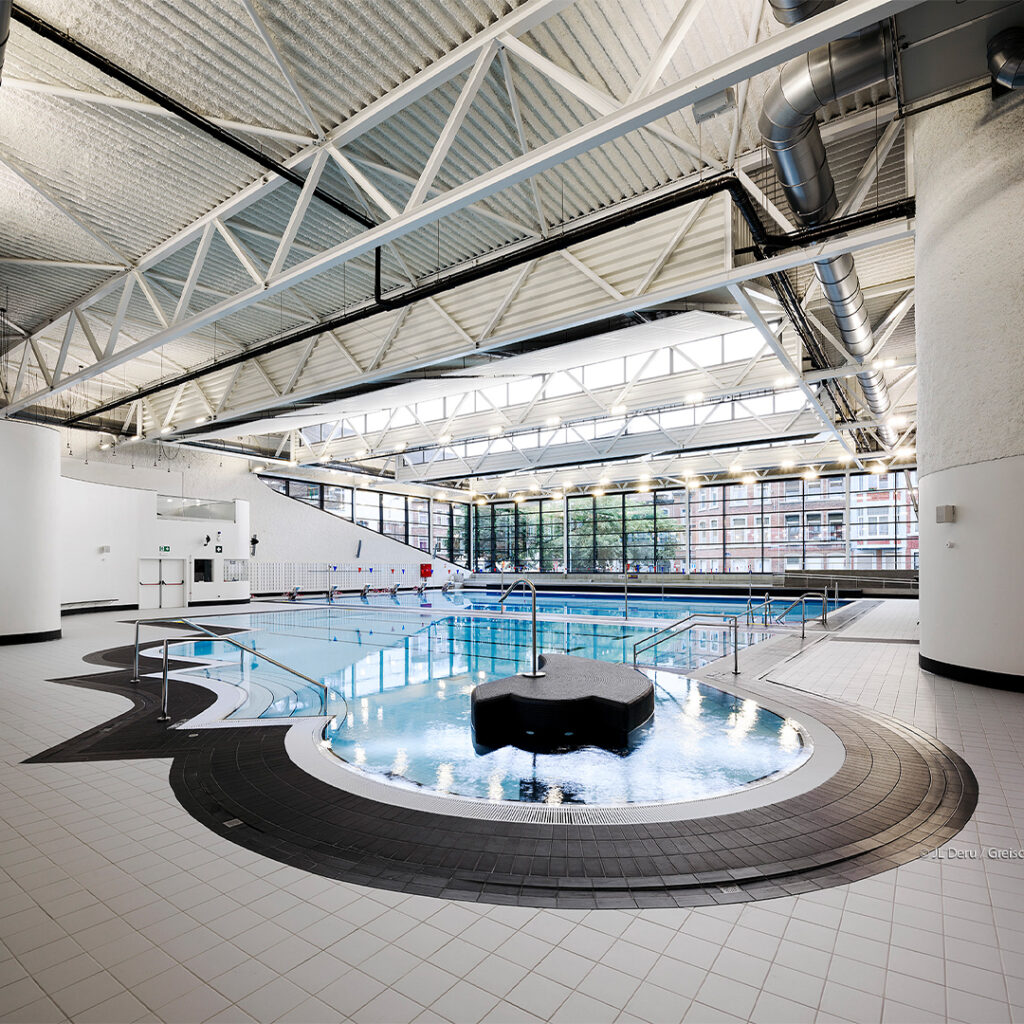 Een zwembad met klimaatbeheersing in een grote binnenruimte.